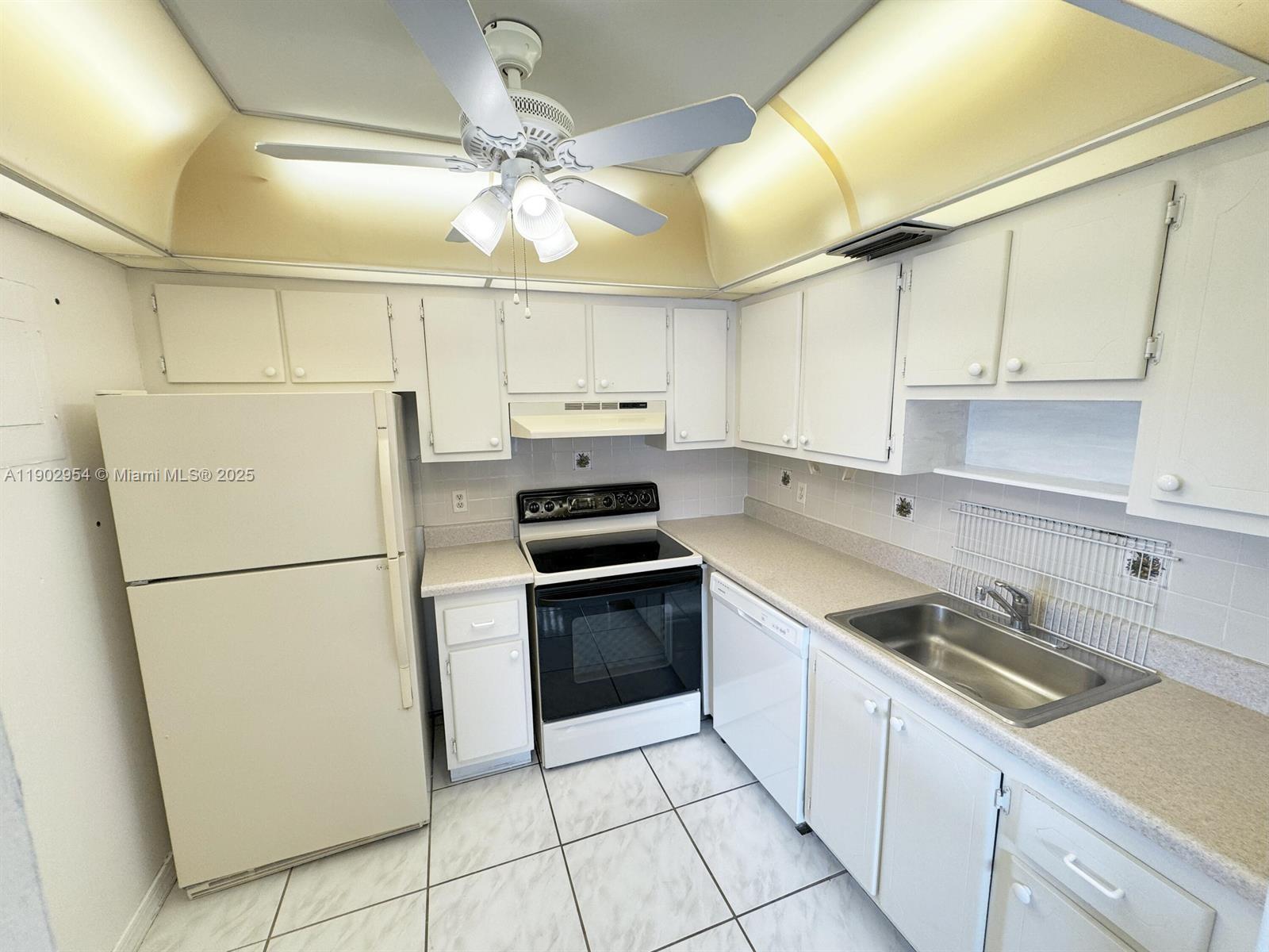 379 Saxony Lane, Unit 379 Delray Beach, FL 33446 - Photo 2 of 16 a kitchen with cabinets stainless steel appliances and a counter space