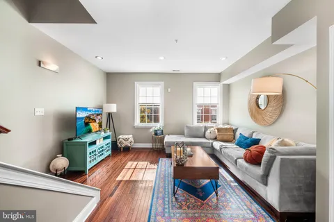 a living room with furniture and a wooden floor