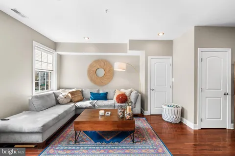 a living room with furniture a rug and a window