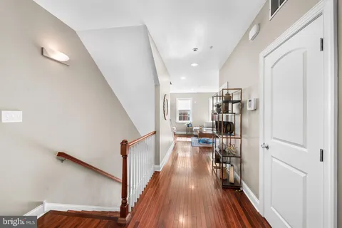 a view of a hallway with wooden floor and staircase