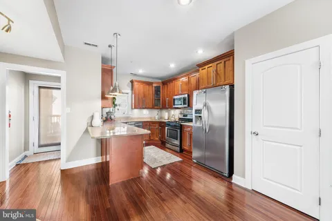 a kitchen with a refrigerator a sink and dishwasher with wooden floor