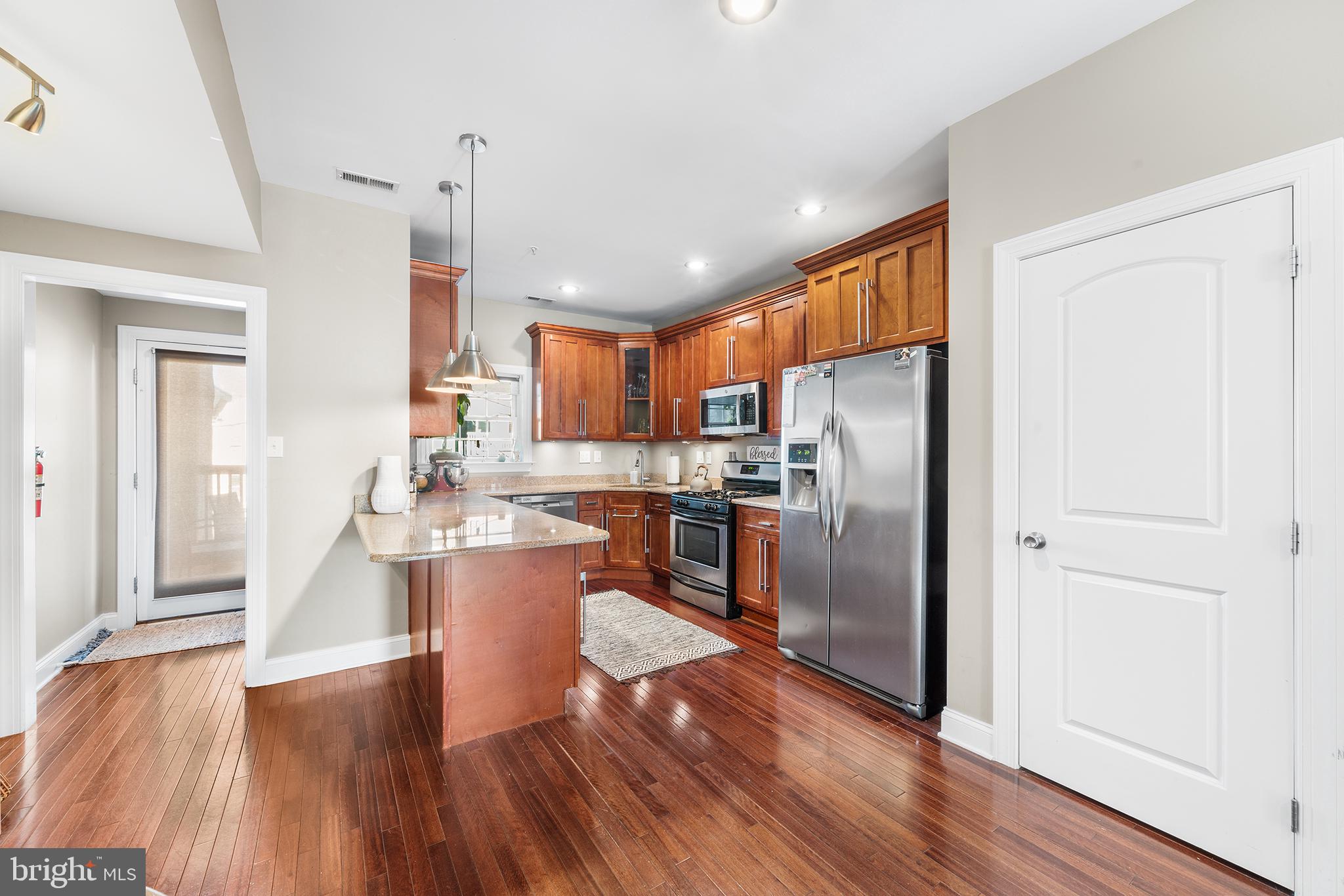 1927 Poplar Street, Unit B Philadelphia, PA 19130 - Photo 8 of 27 a kitchen with a refrigerator a sink and dishwasher with wooden floor
