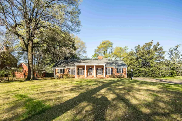 a front view of a house with a garden