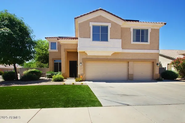a front view of a house with a garden and yard