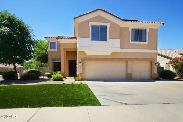 a front view of a house with a garden and yard