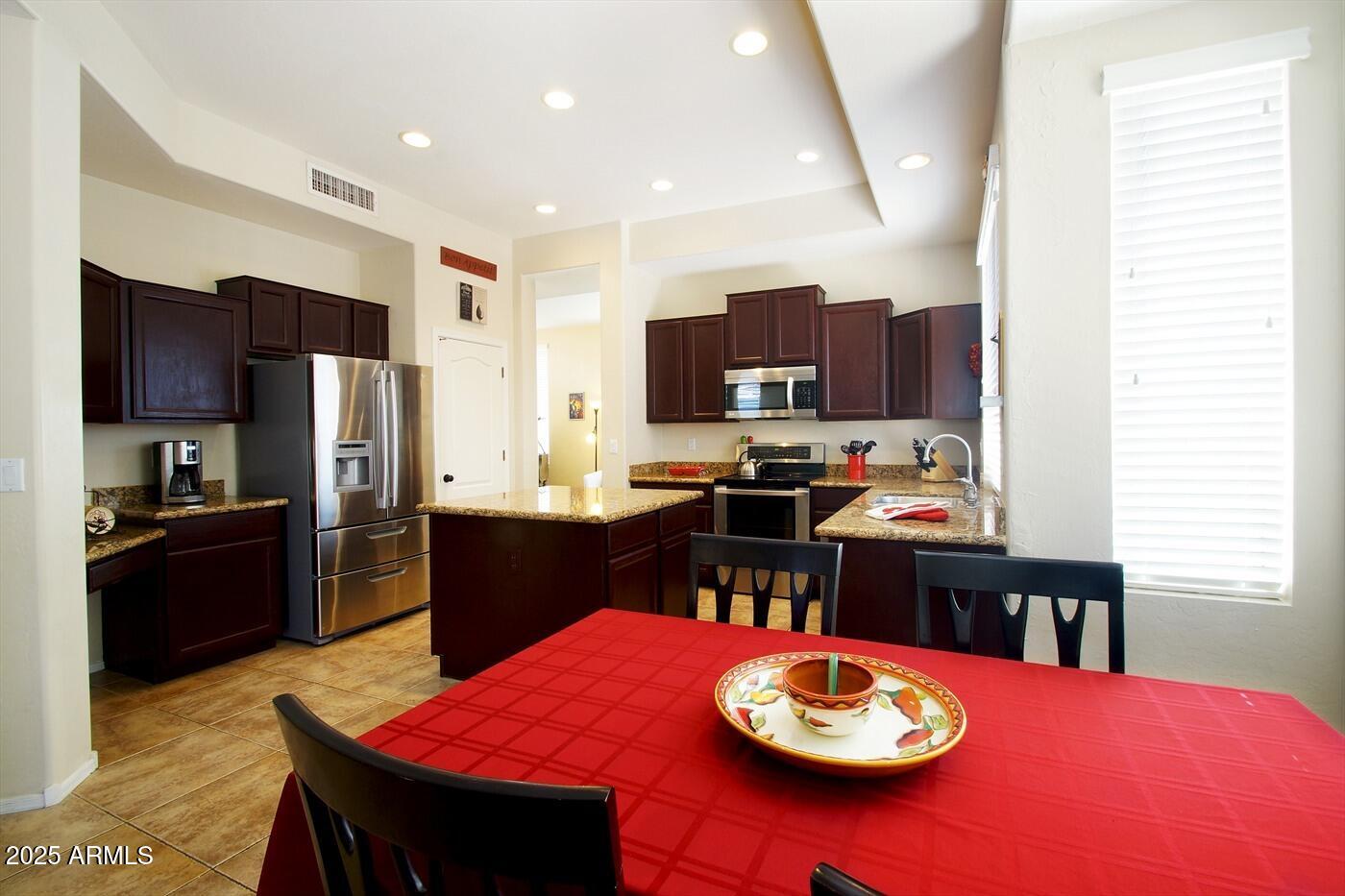 239 West Desert Avenue Gilbert, AZ 85233 - Photo 13 of 38 a kitchen with a refrigerator a stove a sink dishwasher with a dining table and chairs