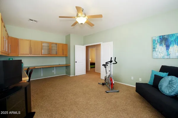 a living room with furniture and a ceiling fan