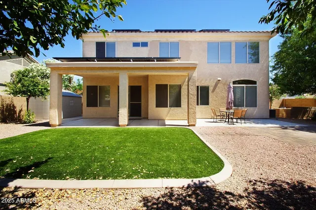 a front view of a house with a yard and trees