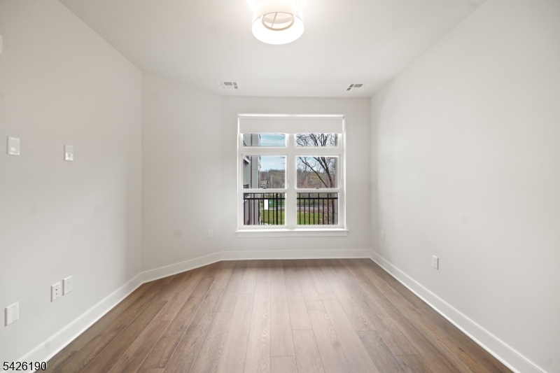 434 Springfield Avenue, Unit 123 Berkeley Heights, NJ 07922 - Photo 20 of 24 an empty room with wooden floor and windows