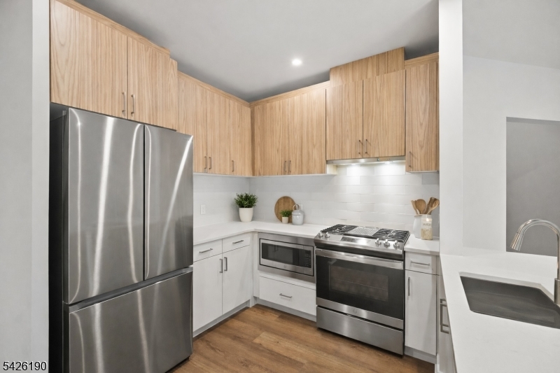 434 Springfield Avenue, Unit 123 Berkeley Heights, NJ 07922 - Photo 4 of 24 a kitchen with a refrigerator sink and cabinets
