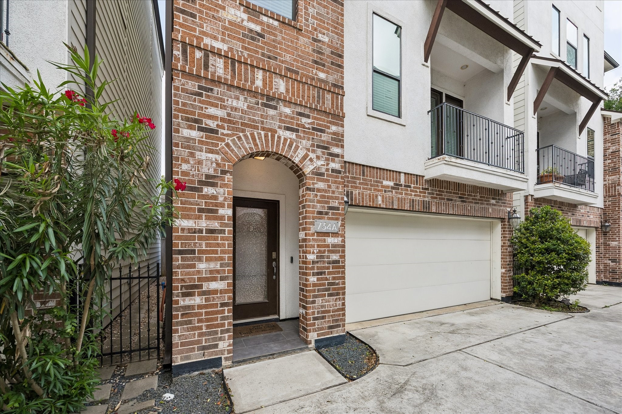 734 West 20th Street, Unit A Houston, TX 77008 - Photo 5 of 23 Charming brick exterior w/ arched entry & attached 2-car garage, offering strong curb appeal & everyday convenience.