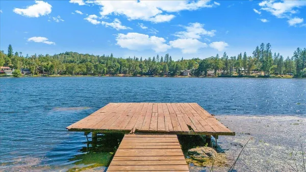 a view of a house with yard and lake view