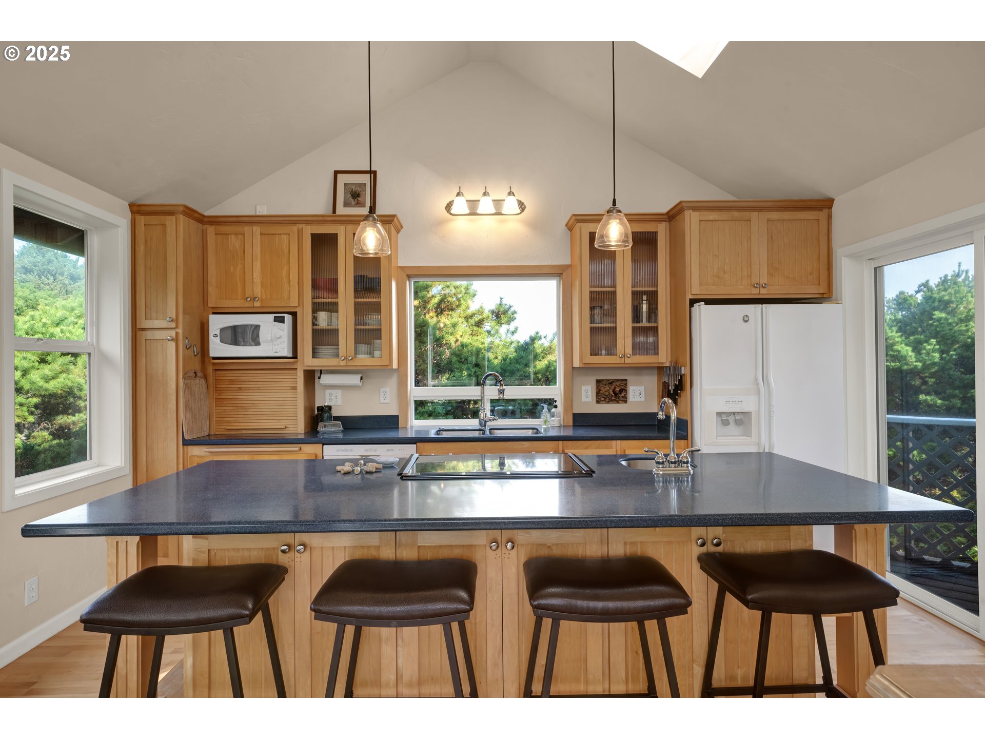 4567 Heceta Street Florence, OR 97439 - Photo 16 of 46 a kitchen with kitchen island granite countertop a stove a sink a counter space and living room view