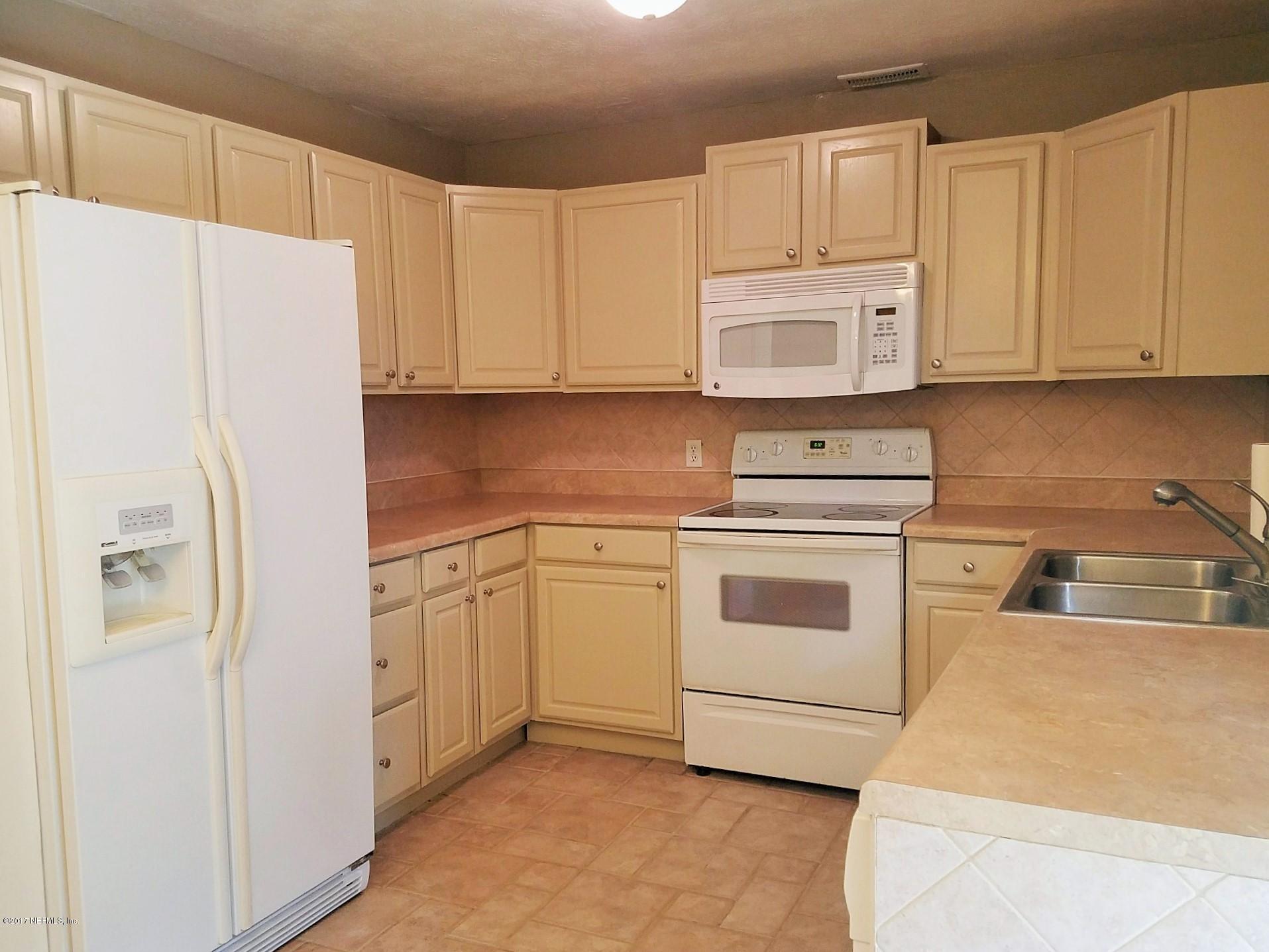 6556 Todd Road Jacksonville, FL 32216 - Photo 5 of 17 a kitchen with cabinets stainless steel appliances and a refrigerator