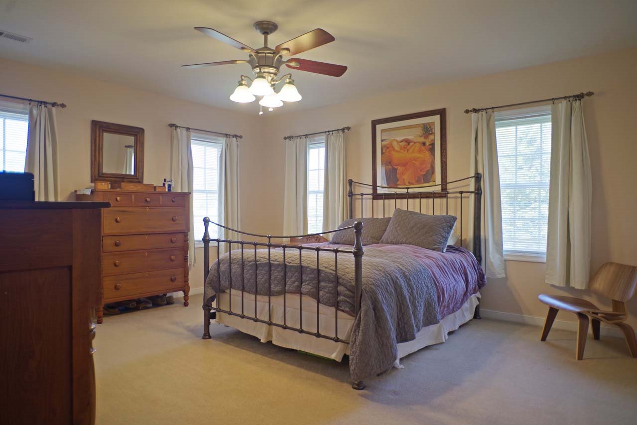 2009 Shepherds Ridge Road Charlottesville, VA 22901 - Photo 22 of 41 a spacious bedroom with a bed chandelier and a window