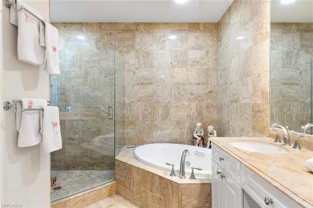 a bathroom with a granite countertop sink and a shower