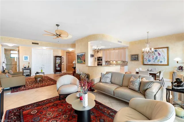 a living room with furniture kitchen and a chandelier