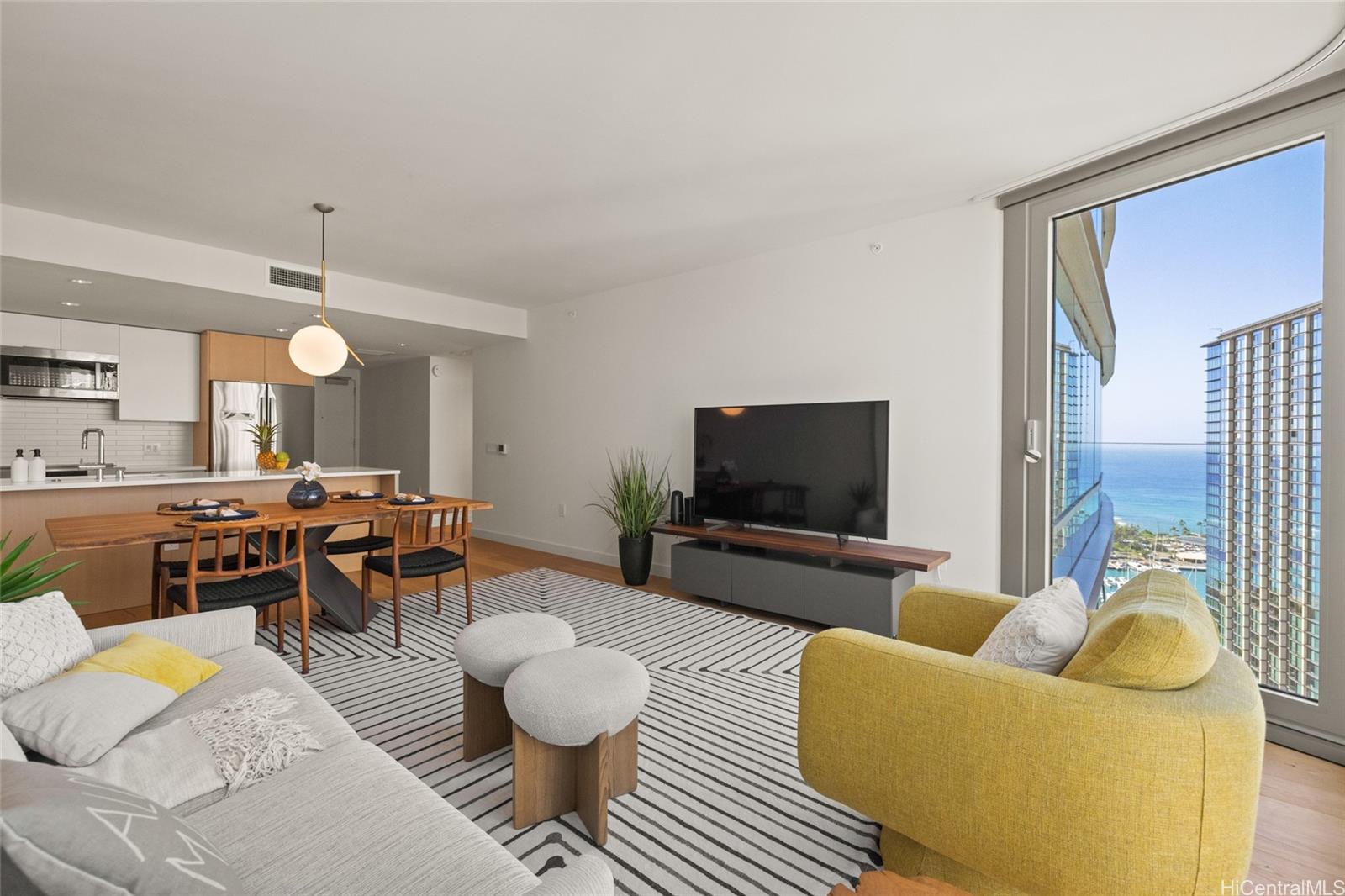 1001 Queen Street, Unit 3103 Honolulu, HI 96814 - Photo 1 of 1 a living room with furniture and a flat screen tv