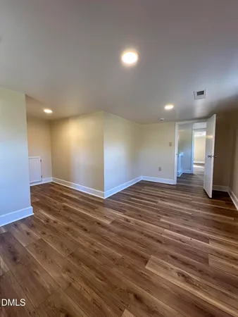 a view of empty room with wooden floor