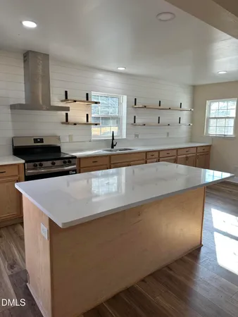 a kitchen with stainless steel appliances granite countertop a sink a stove and a refrigerator