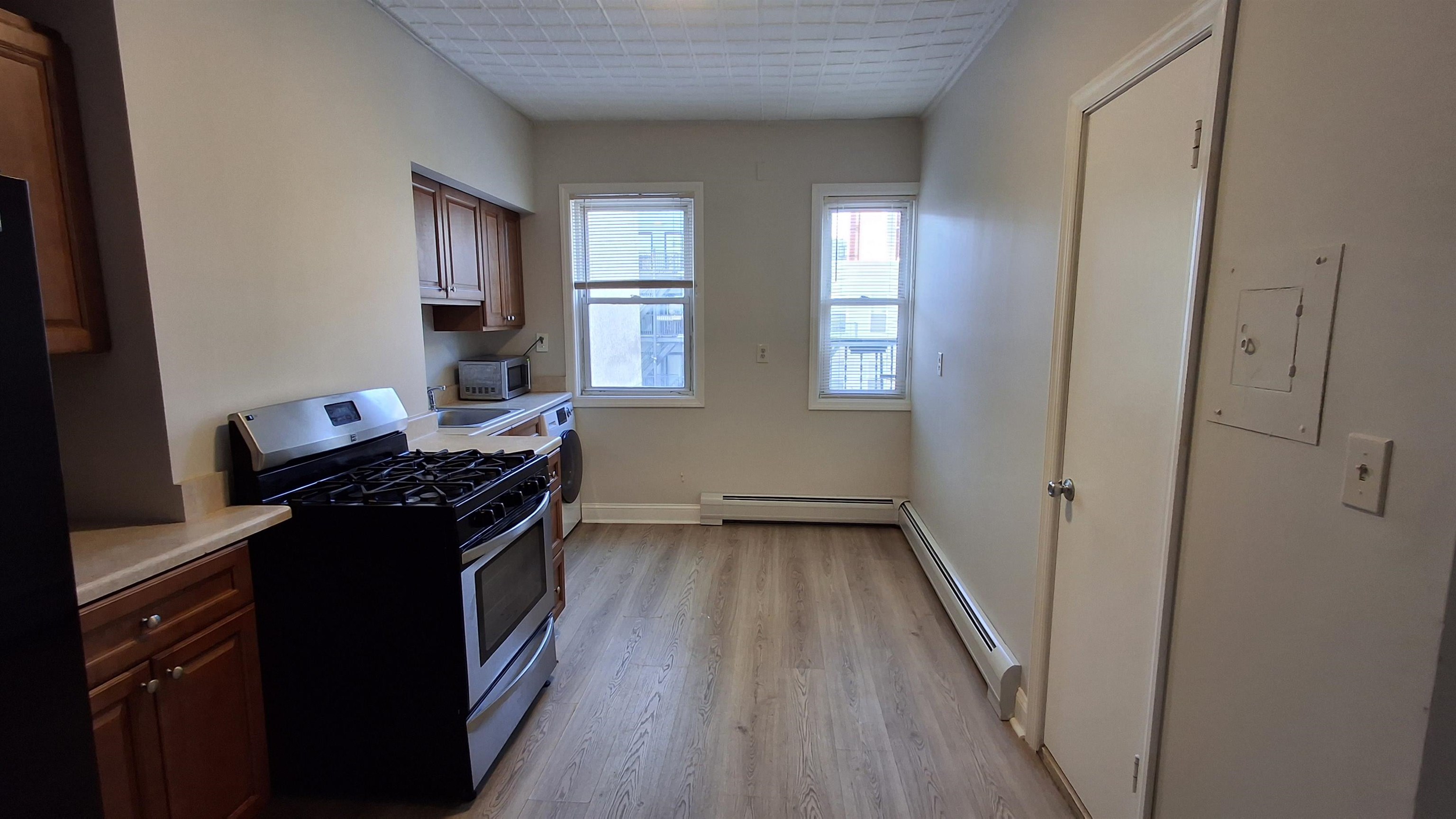 404 Madison Street, Unit 3L Hoboken, NJ 07030 - Photo 2 of 12 a kitchen with granite countertop a stove and a refrigerator