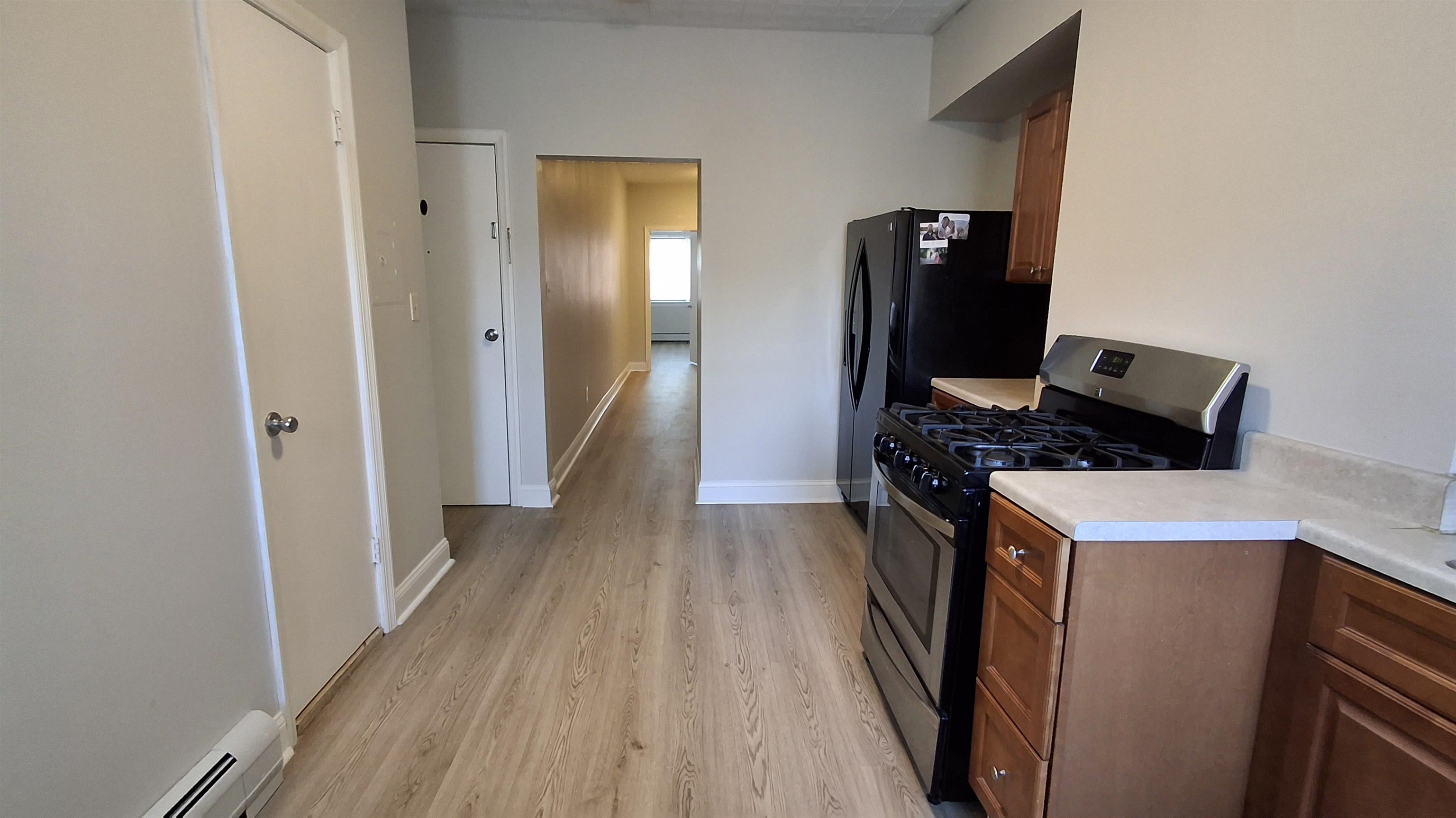 404 Madison Street, Unit 3L Hoboken, NJ 07030 - Photo 3 of 12 a view of a kitchen with refrigerator and wooden floor