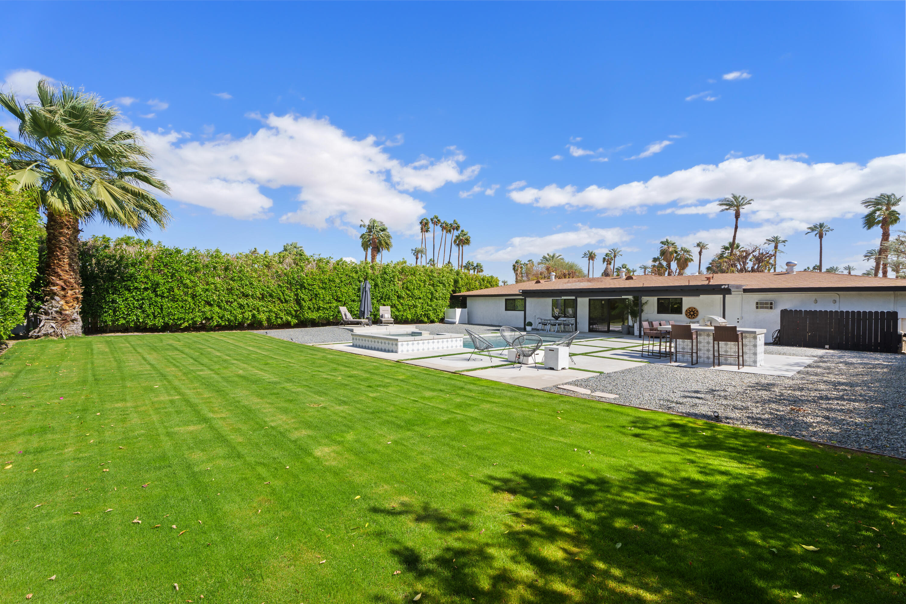 37081 Palmdale Road Rancho Mirage, CA 92270 - Photo 38 of 46 a view of a swimming pool with a table and chairs under an umbrella