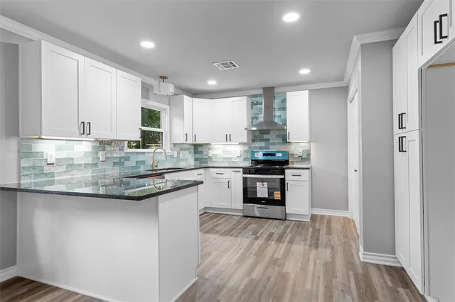 a kitchen with kitchen island granite countertop a sink cabinets and stainless steel appliances