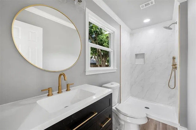 a bathroom with a sink a toilet and shower