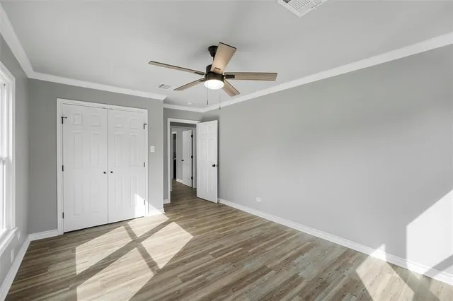 a view of a livingroom with wooden floor and a ceiling fan
