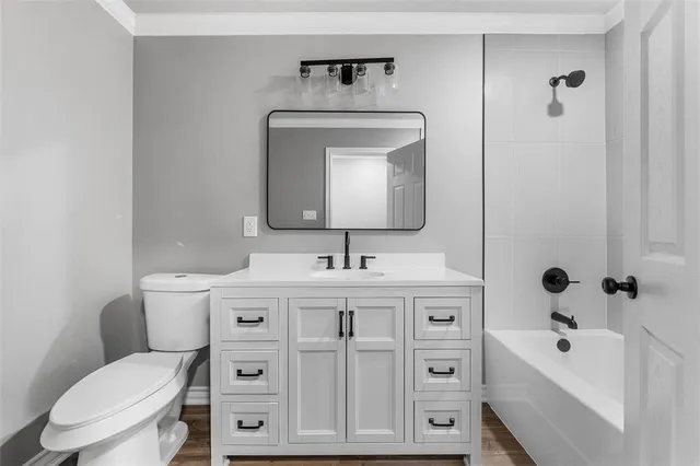 a bathroom with a toilet a sink a vanity and mirror