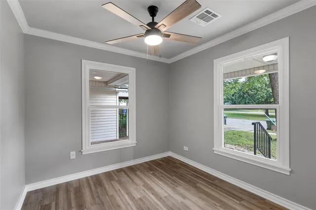 an empty room with window and a ceiling fan