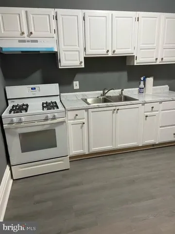 a kitchen with granite countertop white cabinets and white appliances
