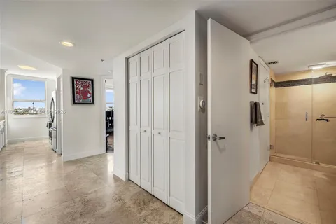 a view of a hallway with wooden floor and cabinet in a room