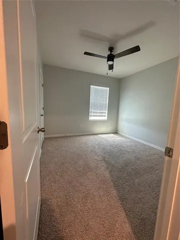 a view of a livingroom with a ceiling fan and window