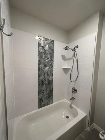 a bathroom with a bathtub and shower