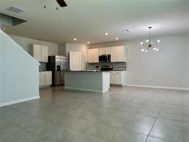 a view of a kitchen with a sink wooden cabinets and stainless steel appliances
