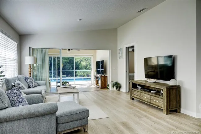 a kitchen with stainless steel appliances granite countertop a dining table chairs refrigerator and sink