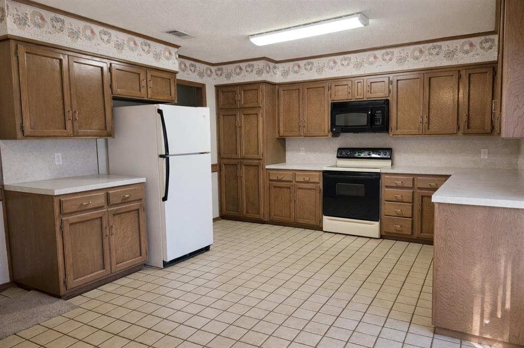 2302 Shiloh Street Denison, TX 75020 - Photo 7 of 16 a kitchen with stainless steel appliances a refrigerator and a stove top oven