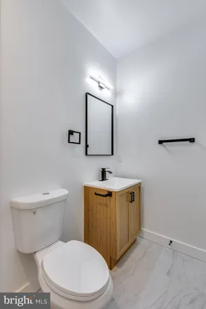 a bathroom with a toilet a sink and mirror