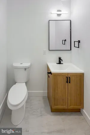a bathroom with a toilet a sink and mirror