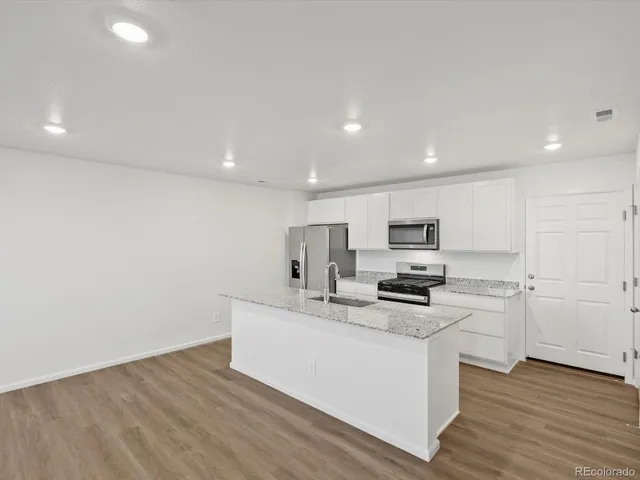 a kitchen with stainless steel appliances a sink a stove a microwave and cabinets