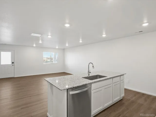 a kitchen with a sink and wooden floor