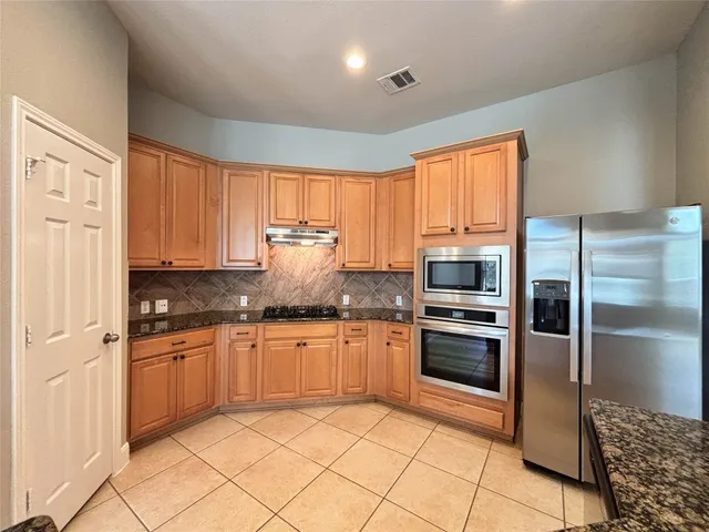 a kitchen with granite countertop a sink and a white cabinets
