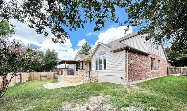 a view of a house with backyard and sitting area