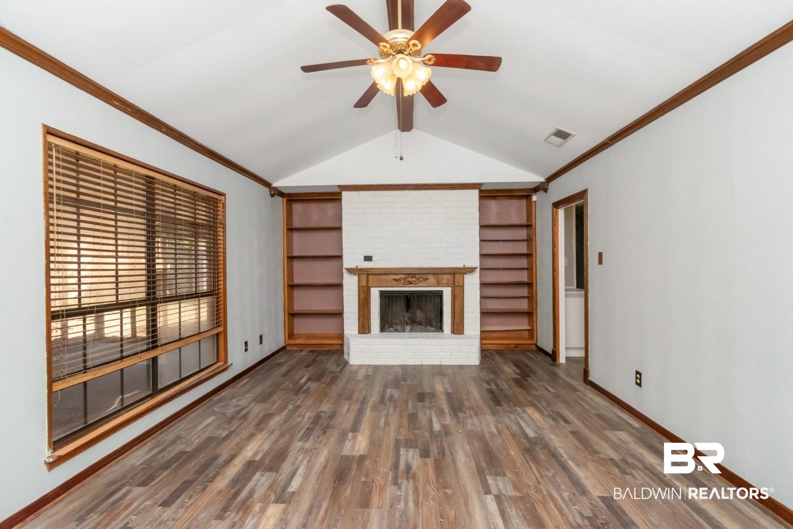 8304 Champlain Circle Mobile, AL 36695 - Photo 21 of 46 Unfurnished living room featuring built in shelves, dark hardwood / wood-style flooring, lofted ceiling with beams, and a brick fireplace