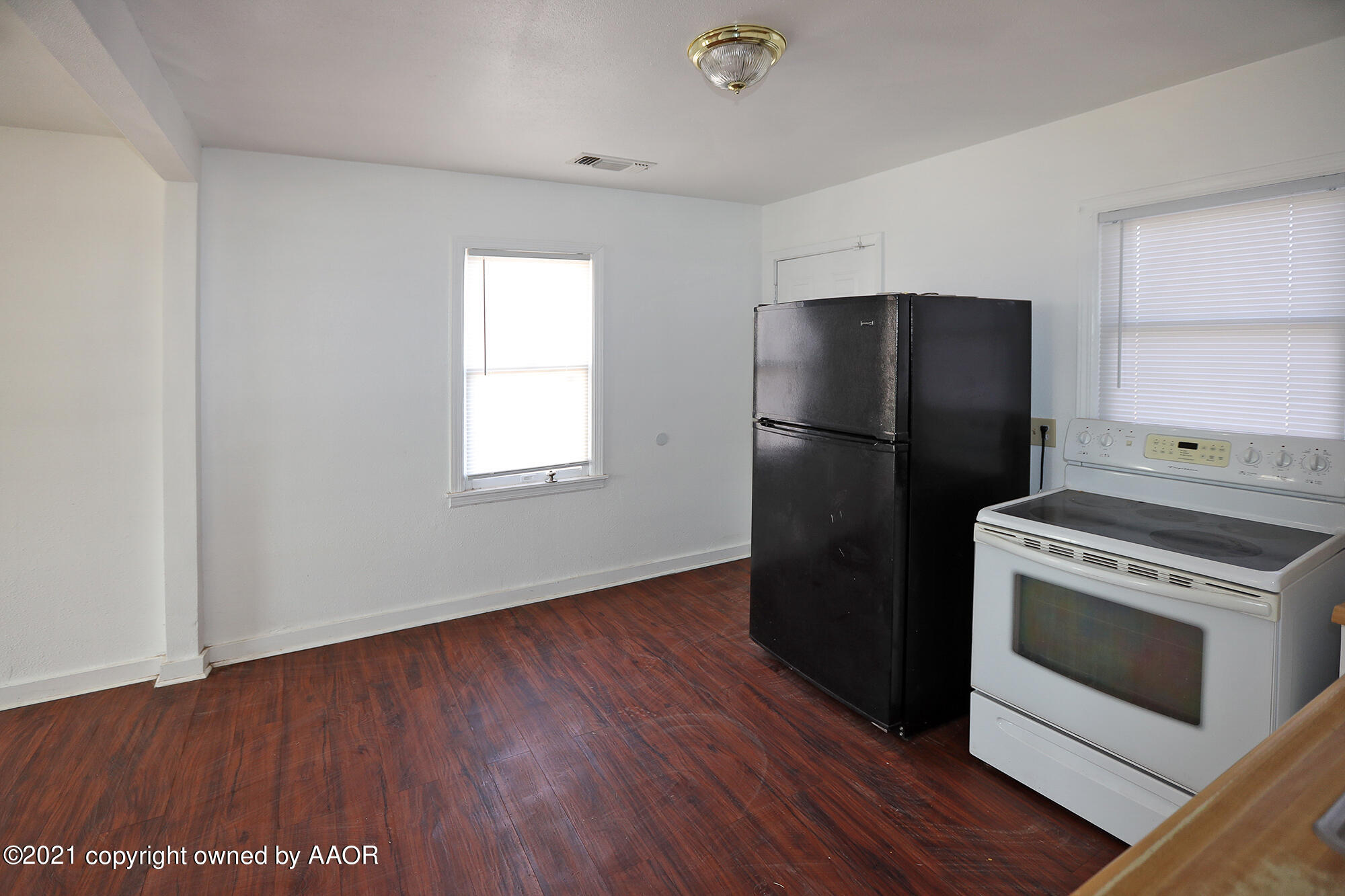 3603 South Ong Street Amarillo, TX 79110 - Photo 6 of 13 a kitchen with a refrigerator stove and wooden floor
