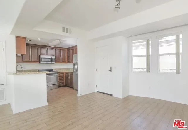 a kitchen with a refrigerator sink and cabinets