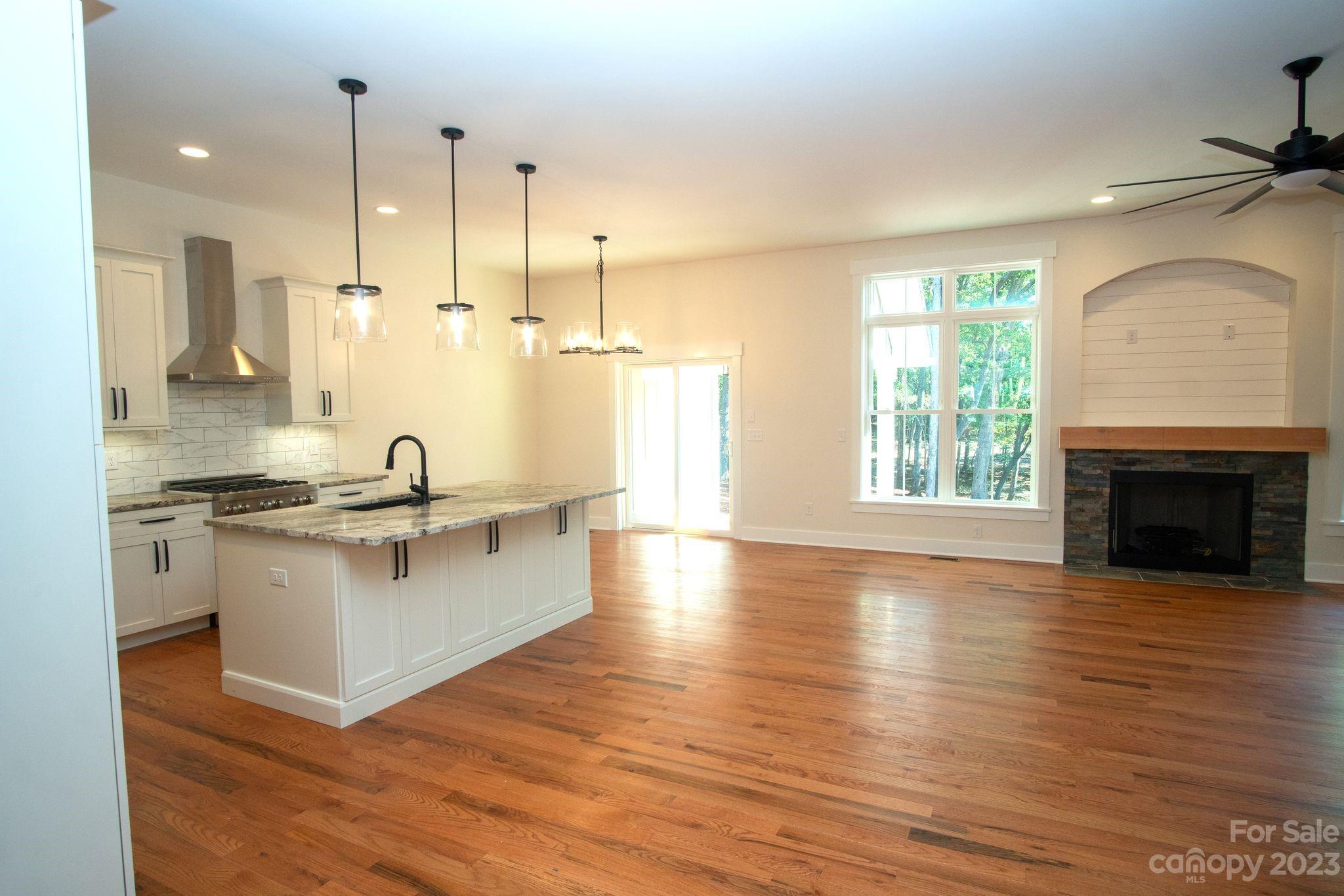 1495 Golf Course Road Columbus, NC 28722 - Photo 14 of 47 a large kitchen with granite countertop a stove top oven a sink a counter space and wooden floor