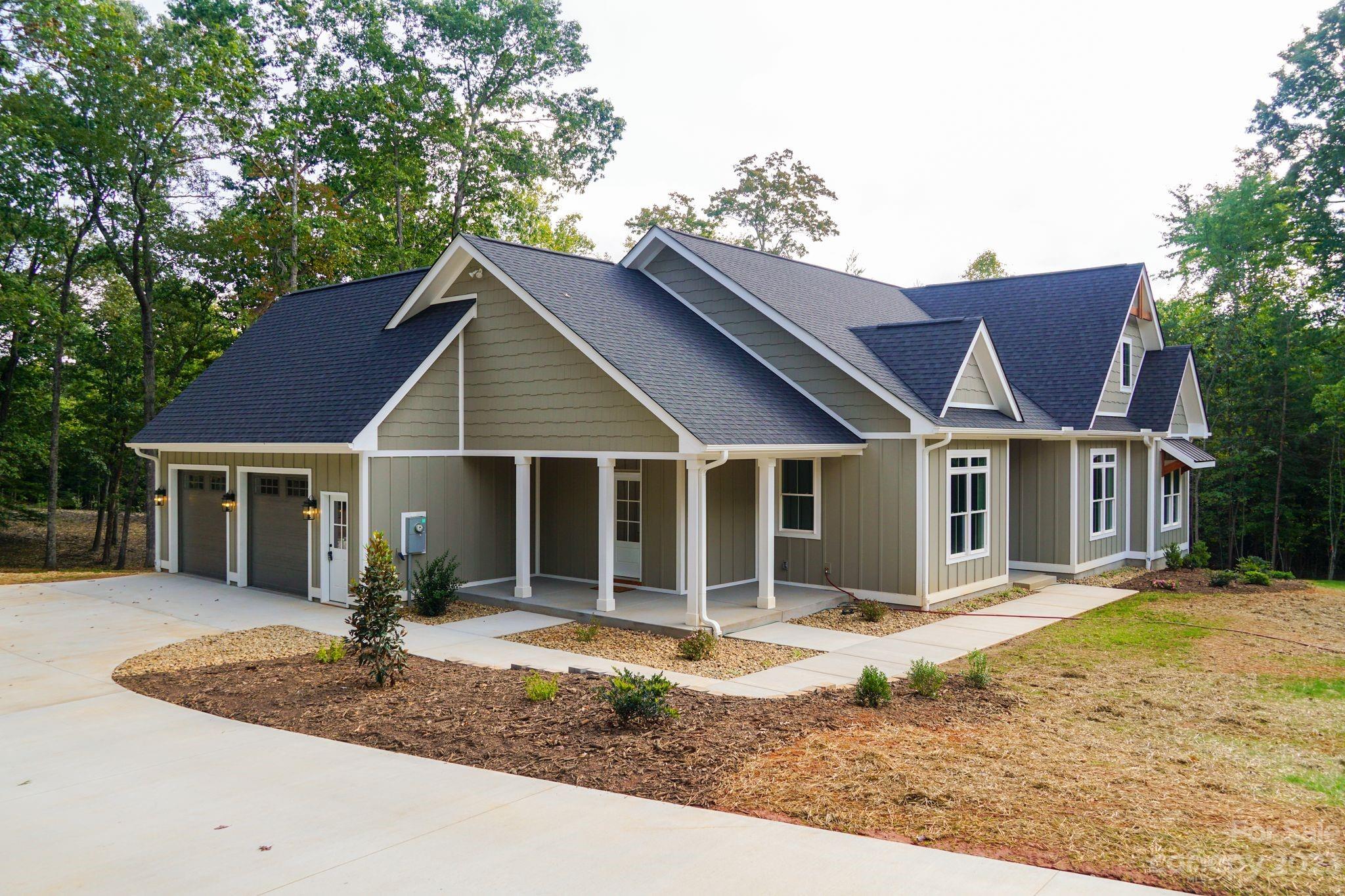 1495 Golf Course Road Columbus, NC 28722 - Photo 2 of 47 a front view of a house with a yard and potted plants